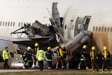 Fire engines smothered the Boeing 777 in foam after it landed with its wings extensively damaged and its undercarriage wrecked.
