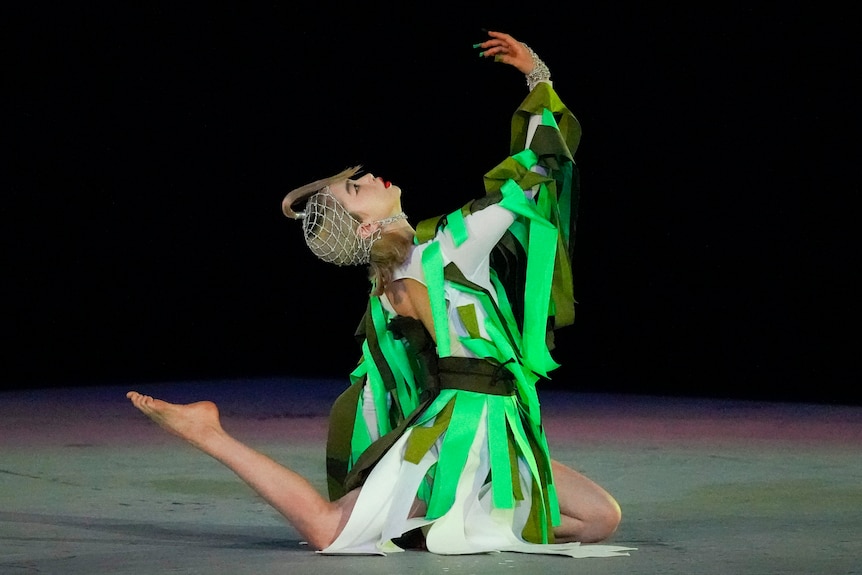 A performer clad in green to resemble a tree performs a Japanese dance at the Olympics closing ceremony.