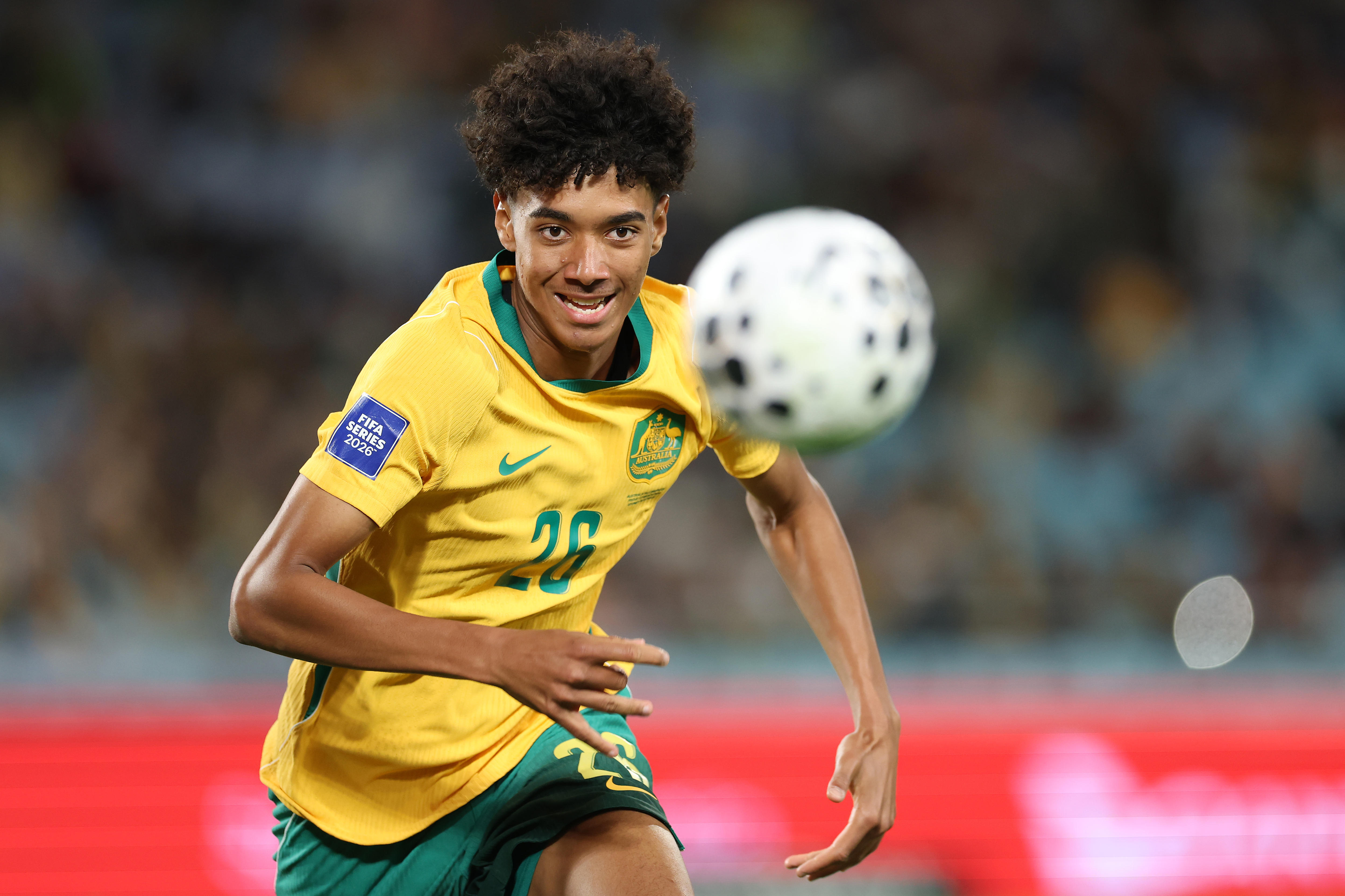 O jogador do Socceroos Lucas Herrington está correndo em direção à bola durante um jogo