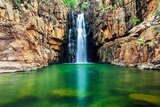 A waterfall falls into the Southern Rockhole at Nitmiluk, Northern Territory