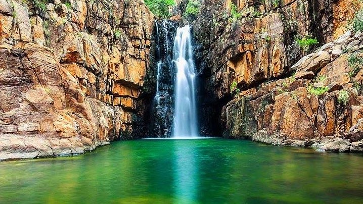 A waterfall falls into the Southern Rockhole at Nitmiluk, Northern Territory