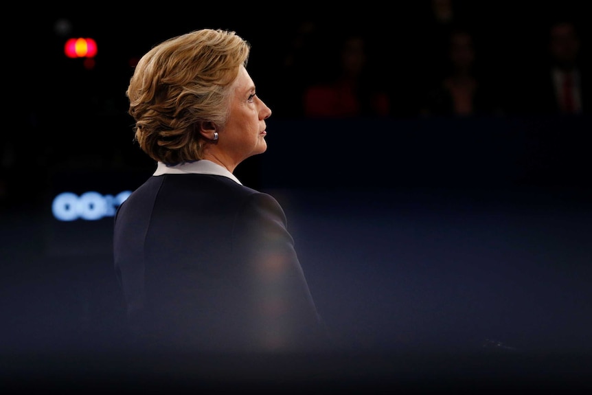 Hillary Clinton stands alone and listens to Trump during second presidential debate.