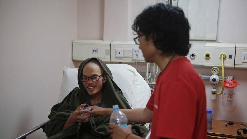 Liang Sheng-yueh sits in a hospital bed.