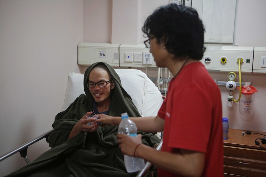 Liang Sheng-yueh sits in a hospital bed.