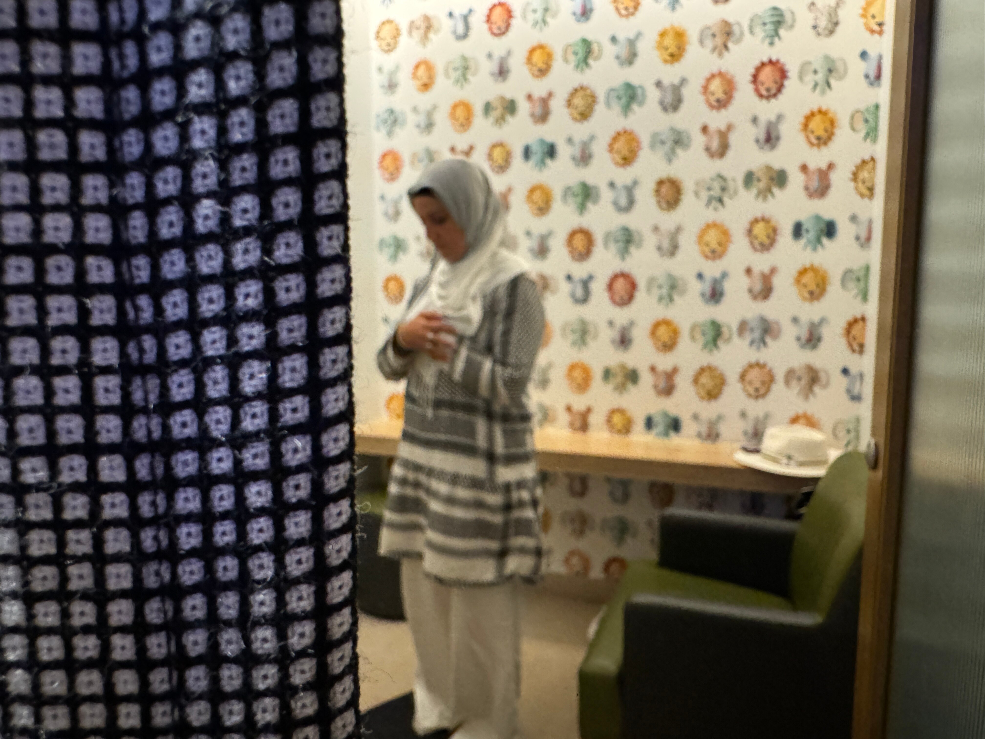 Yeliz Deveci prays while standing behind a curtain.