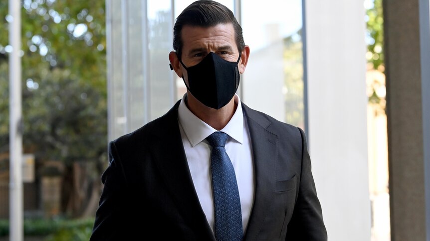 A man wearing a suit and a face mask