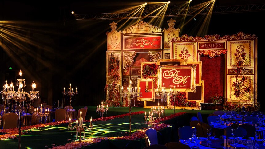 A stage covered with decorations in gol and red colors.