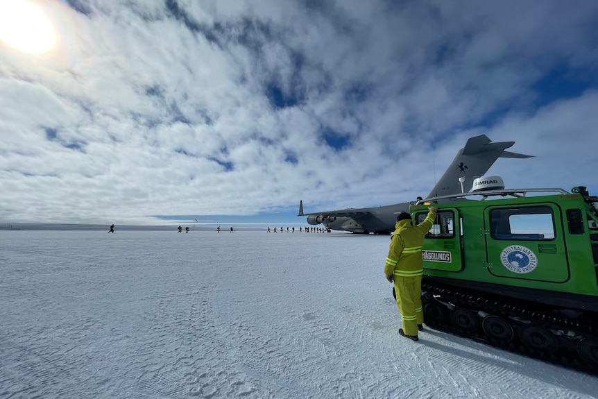 A transport vehicle and a plane in the Antarctic landscape