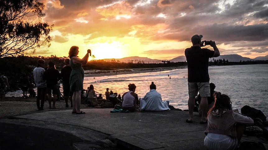 Amateur photographers snap a beautiful sunset.