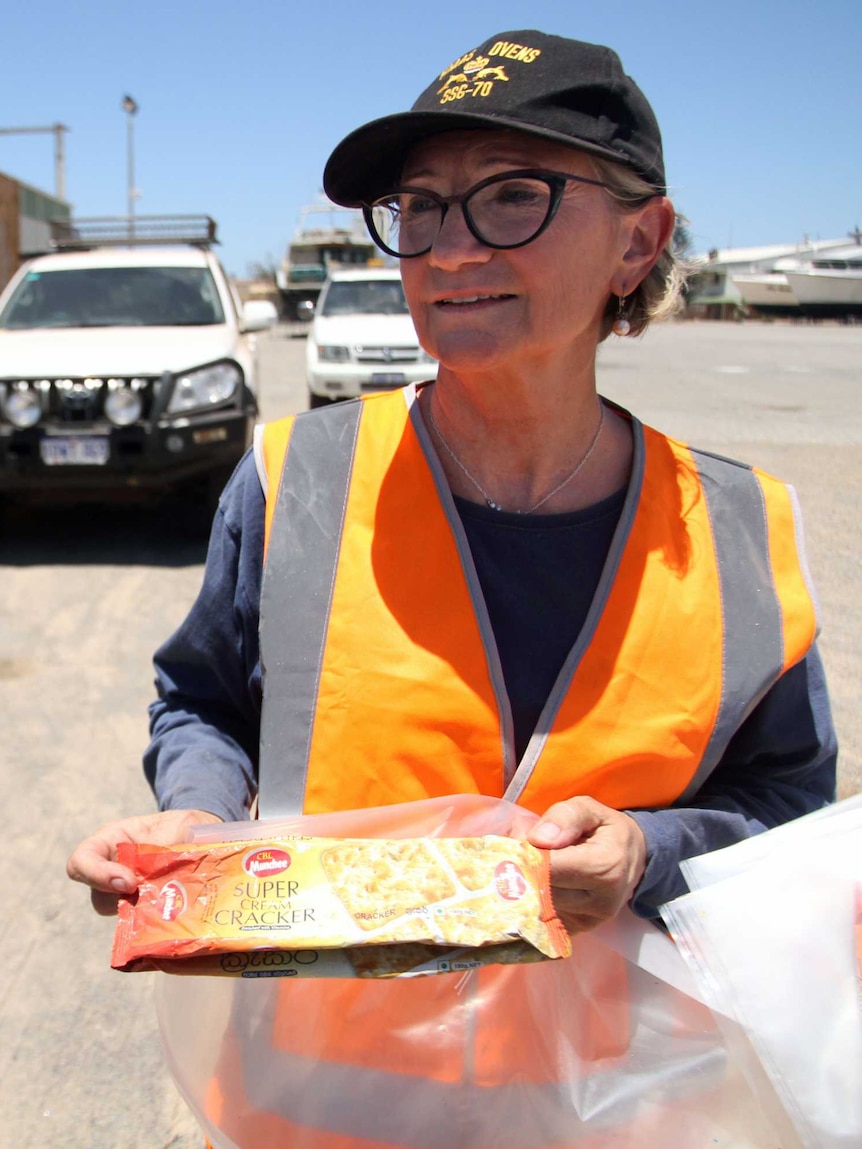 The WA Museum's head of maritime history, Sally May holding a packet of cracker biscuits found on the asylum seeker boat.