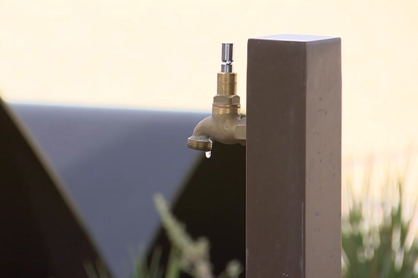 A tap with brass handle removed in a park.