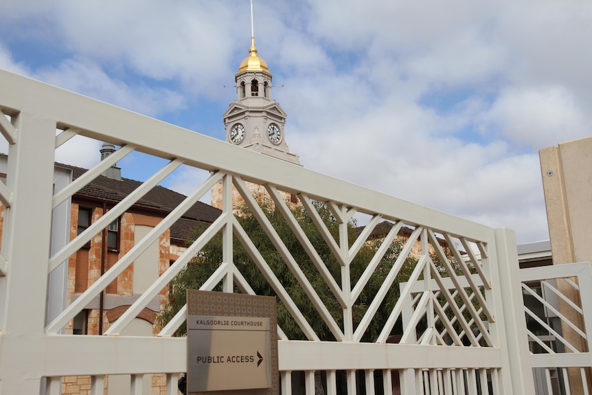 The exterior of a court building, with a tower and a gold-coloured dome on it  