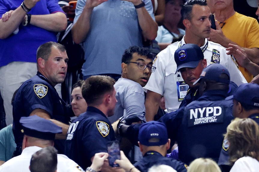A protester being taken away by police at the US Open.