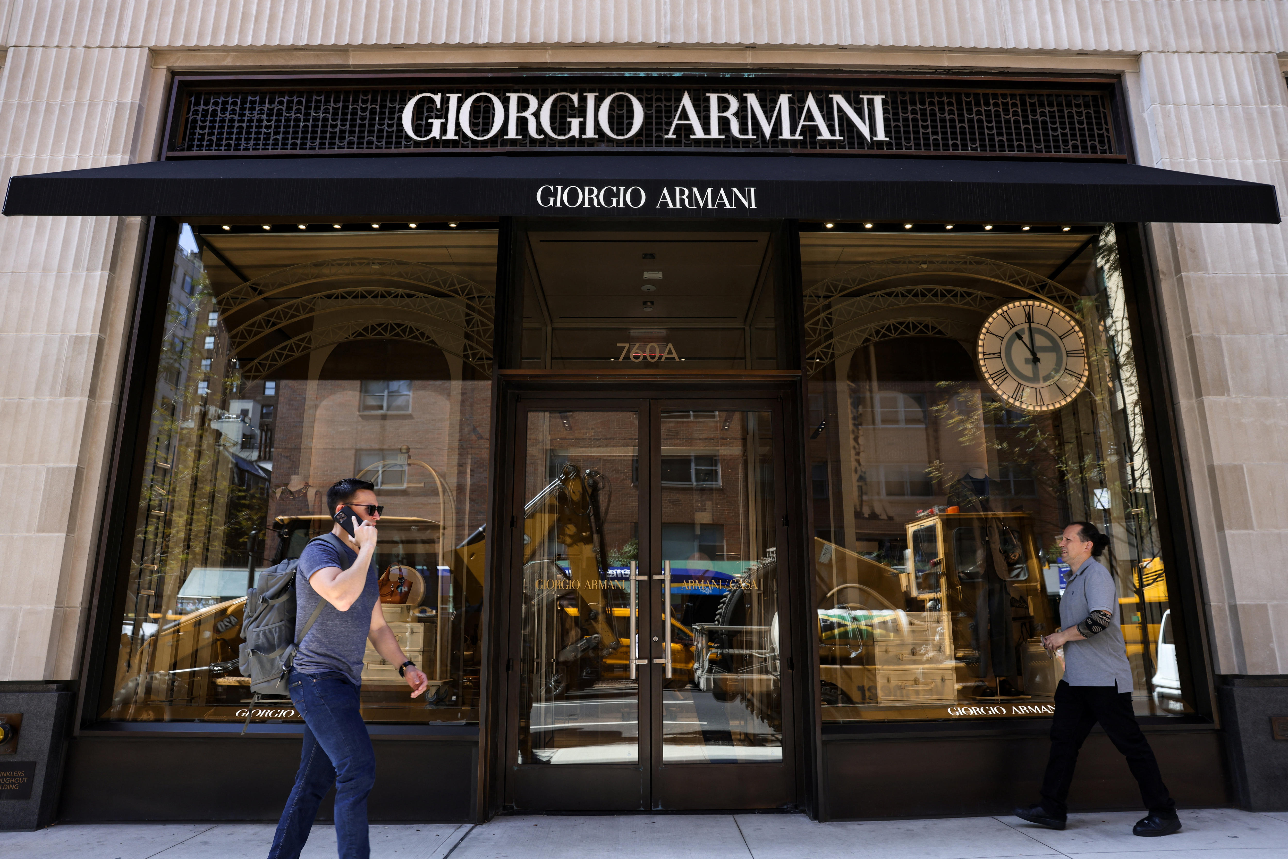 A man walks past a giorgio armani shopfront