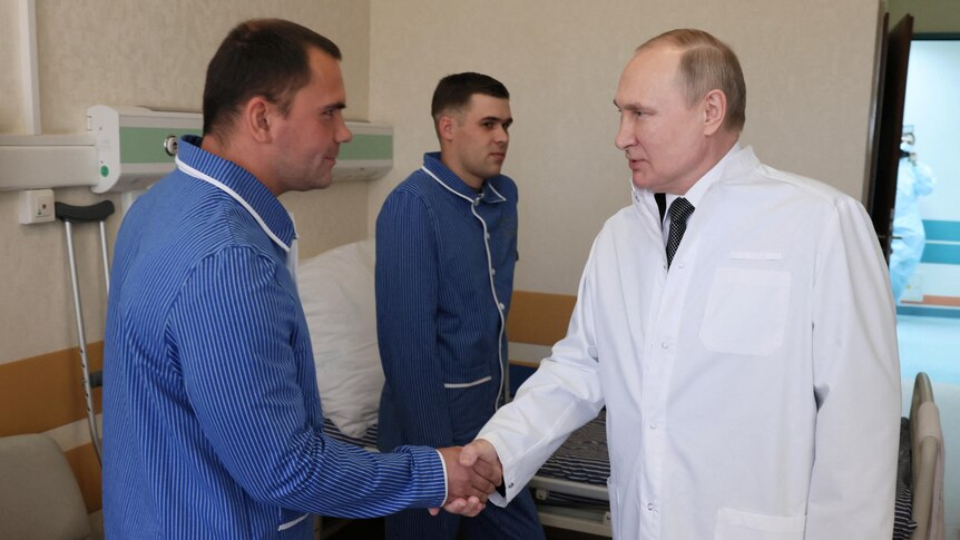 Russian President Vladimir Putin shakes hands with wounded soldiers