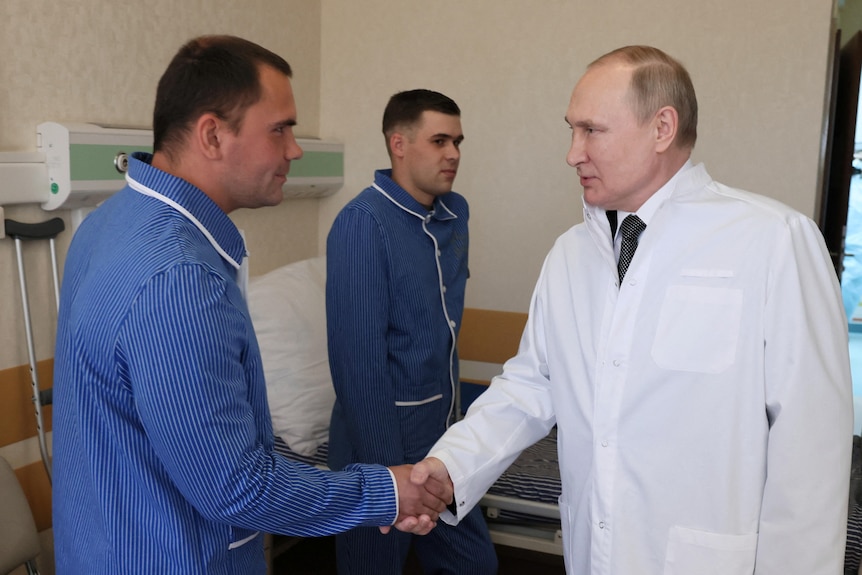 Russian President Vladimir Putin shakes hands with wounded soldiers