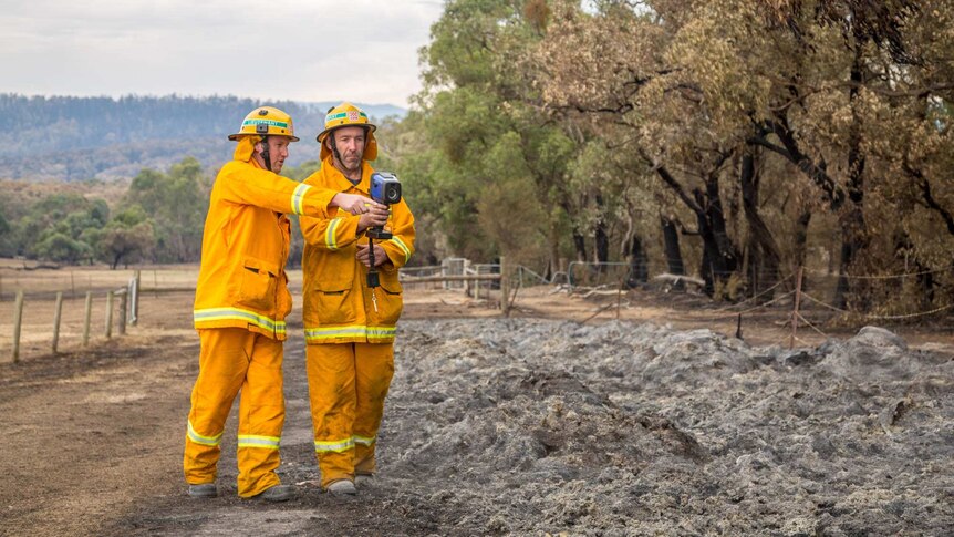 Roy Wilding and Gavin Blair inspect the hot paddock which is burning underground.