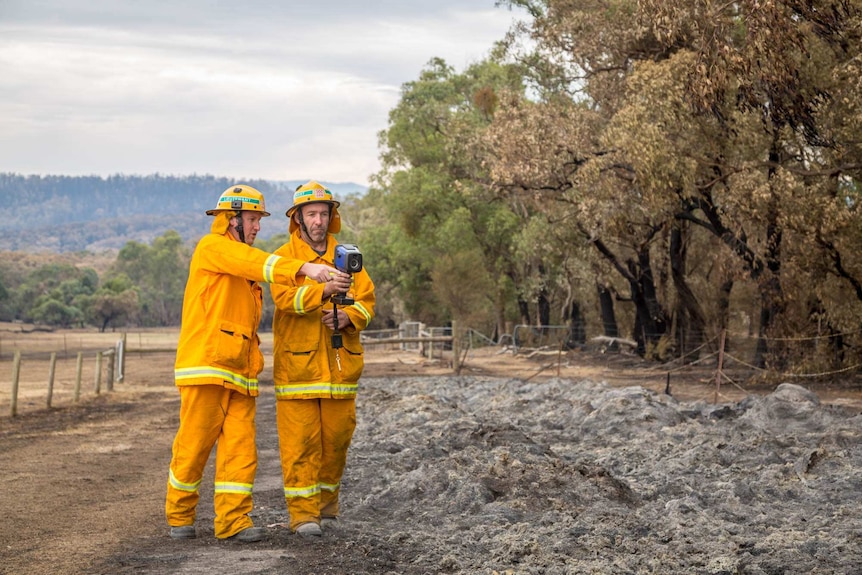 Roy Wilding and Gavin Blair inspect the hot paddock which is burning underground.