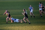 Ainslie player takes off with the ball while others chase her.