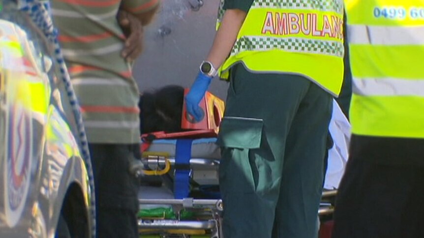 Emergency crews around a person on an ambulance stretcher.