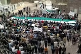 Image grab from YouTube shows anti-government protesters waving former Syrian flag.