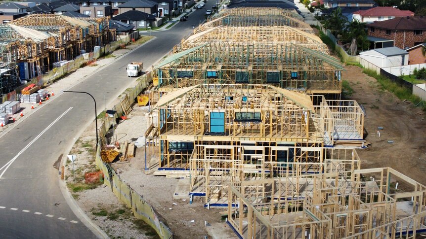 An overhead shot of wooden housing frames being built on a street.