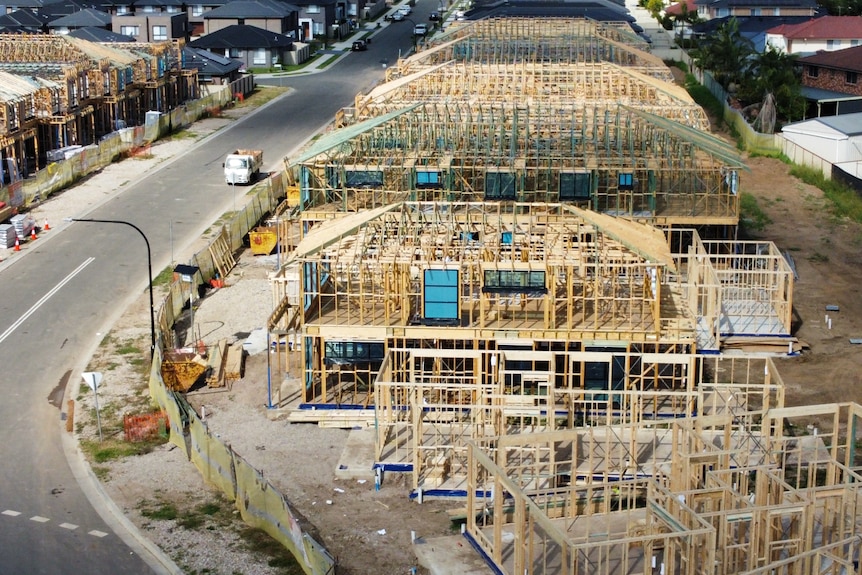 An overhead shot of wooden housing frames being built on a street.