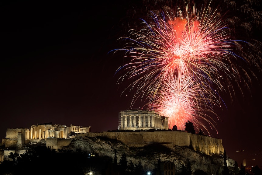 Fireworks explode over the ancient Parthenon temple at the Acropolis in Athens.
