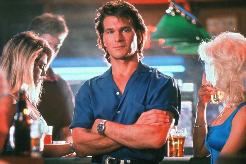 Patrick Swayze poses with folded arms in the film Road House