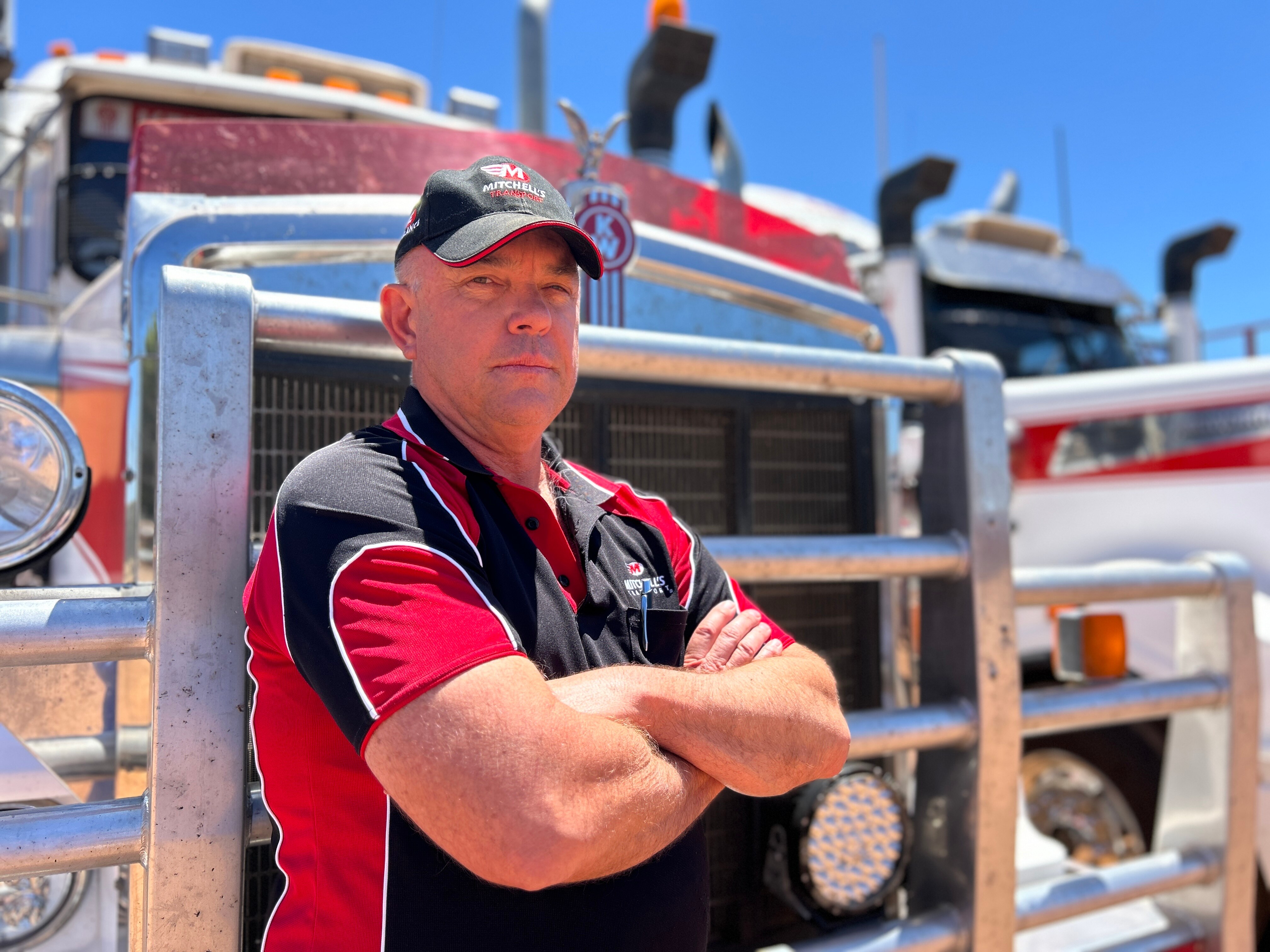 John Mitchell standing with arms crossed in front of his truck