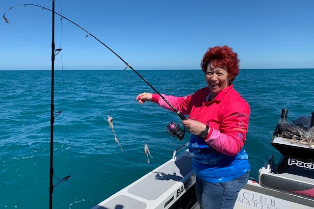A woman holding a fishing rod in a boat