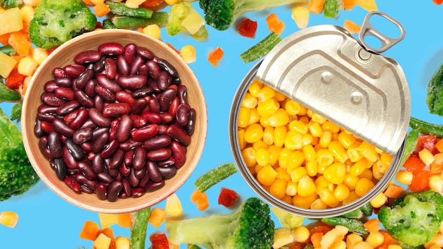 A bowl of kidney beans sits left next to a half-opened can of corn on the right, on top of a blue background with frozen veg