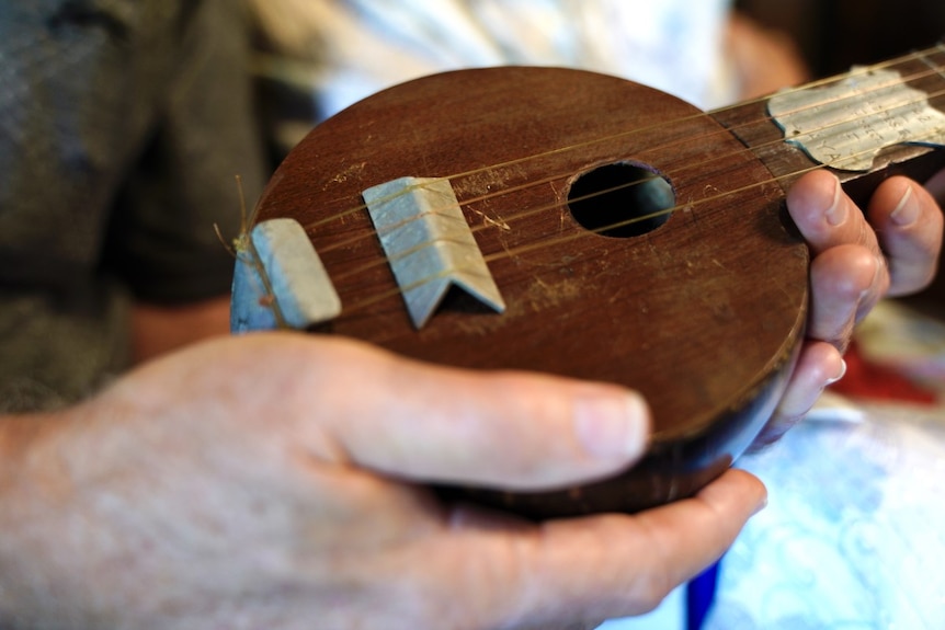 A close-up of the body of a handmade ukulele made from a coconut shell
