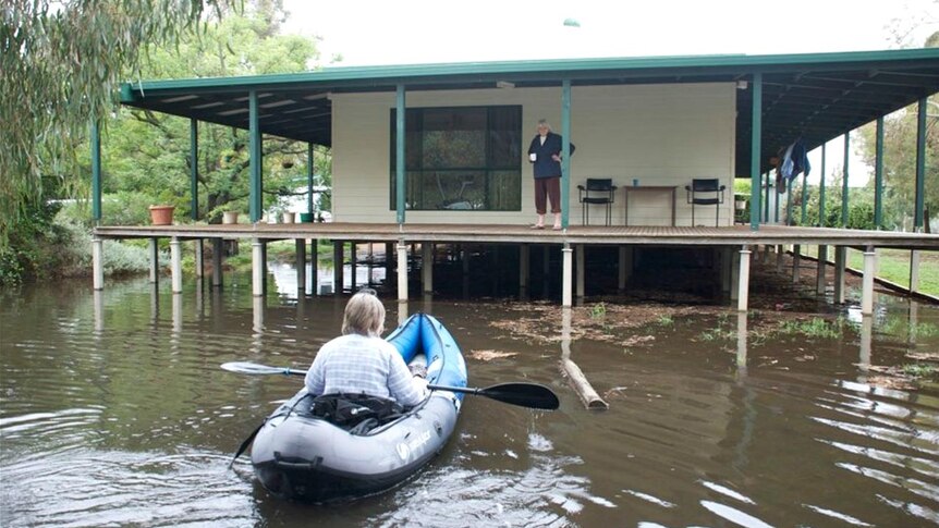 A canoeist approaches a house in Wunghnu during floods.
