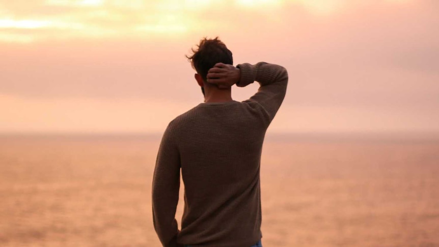 A man looks out over a body of water.