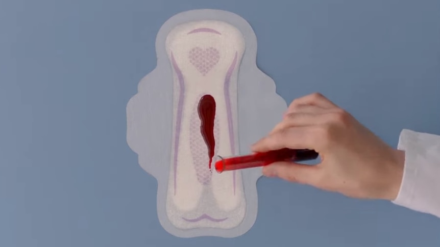 Red liquid is poured onto a period pad showing its absorbency in a TV advertisement.