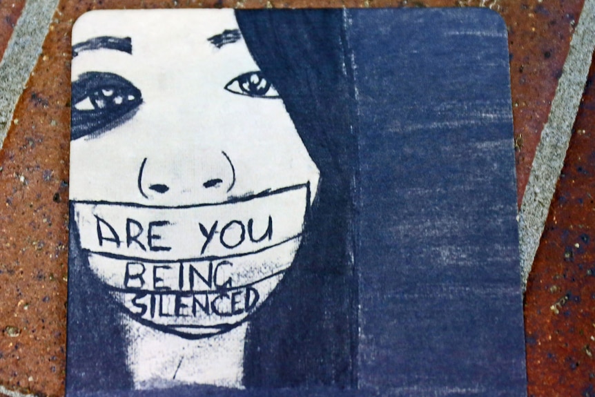 'Are you being silenced' message taped across sketch of a woman