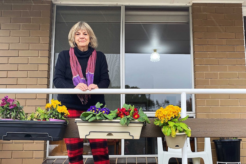 a woman sitting on her balcony alone