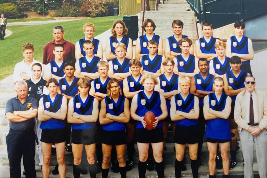 a group of young footballers pose for a photograph wearing their footy uniforms