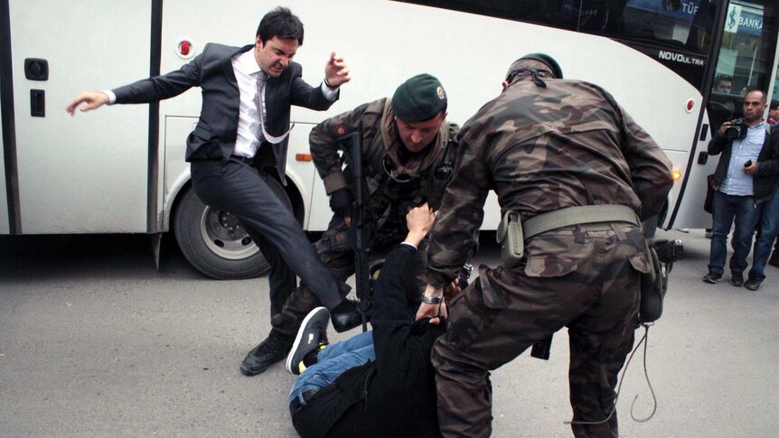 A man identified by Turkish media as Yusuf Yerkel kicks a protester.