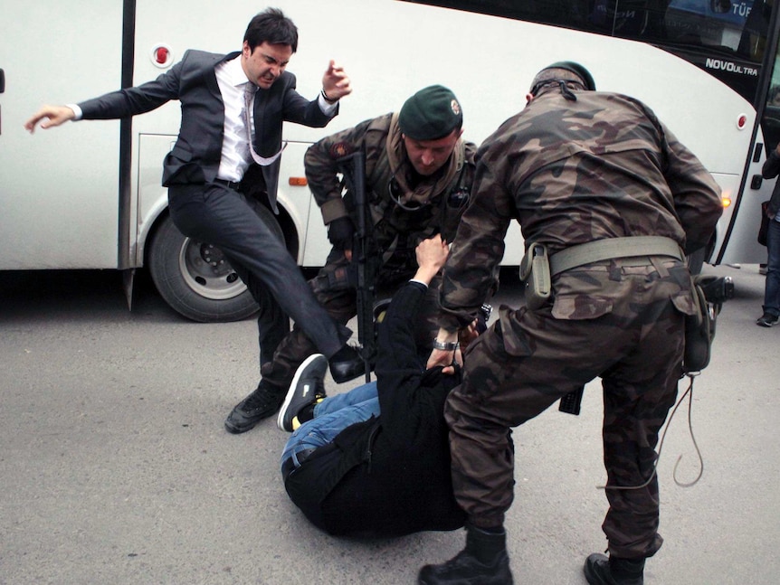 A man identified by Turkish media as Yusuf Yerkel kicks a protester.