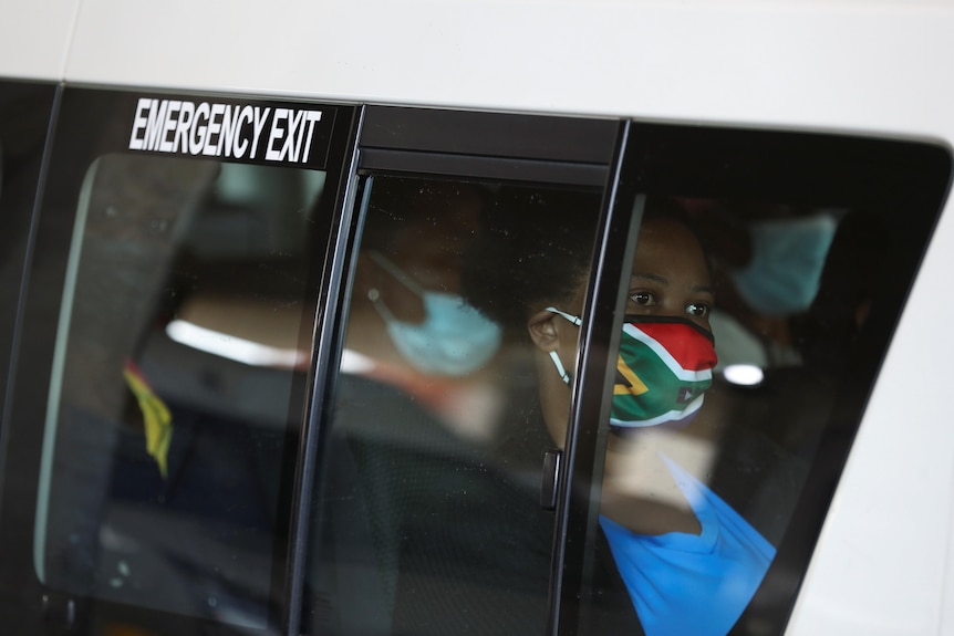 woman in a taxi with a south african flag mask