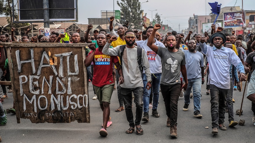 Residents march down the street in protest against the United Nations peacekeeping force.