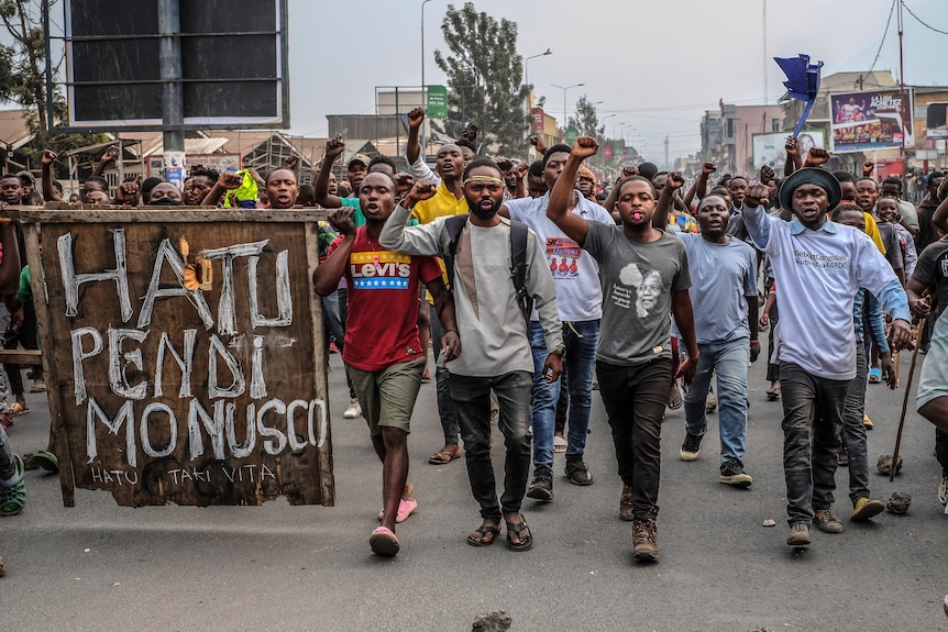 Residents march down the street in protest against the United Nations peacekeeping force.