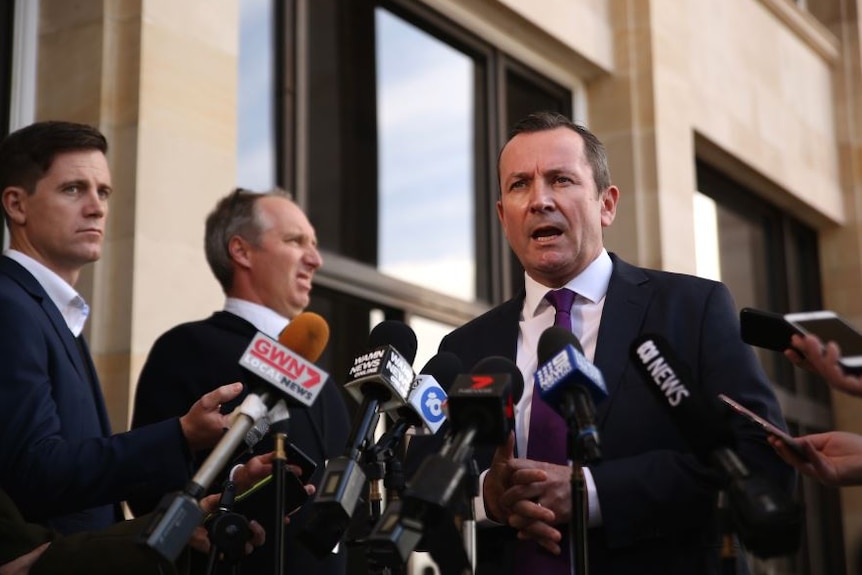 Mr McGowan speaks into a nest of microphones in front of Parliament House.