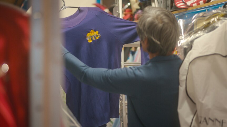 Jeff Fatt from behind, holding up his purple Wiggles skivvy.