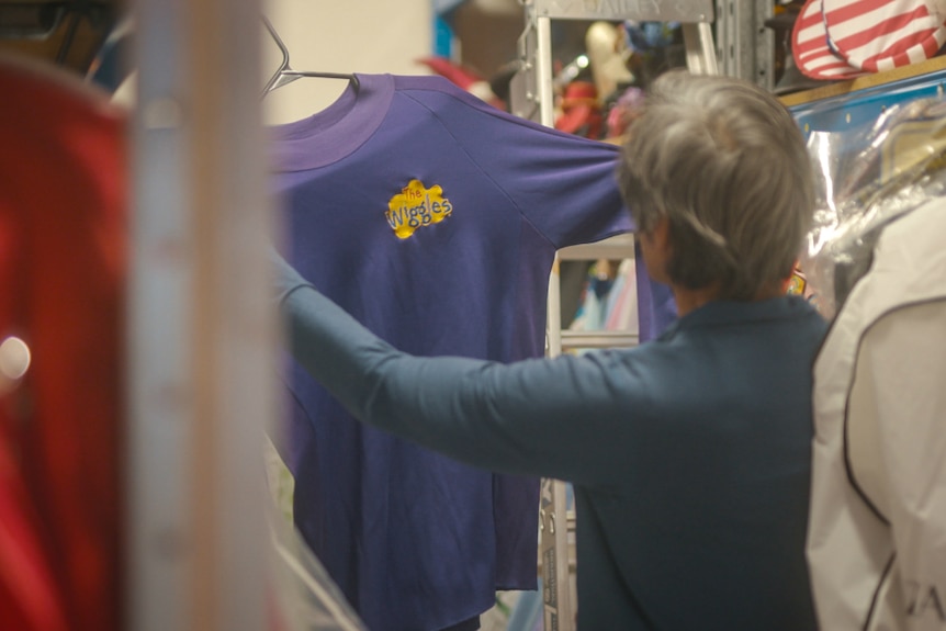 Jeff Fatt from behind, holding up his purple Wiggles skivvy.