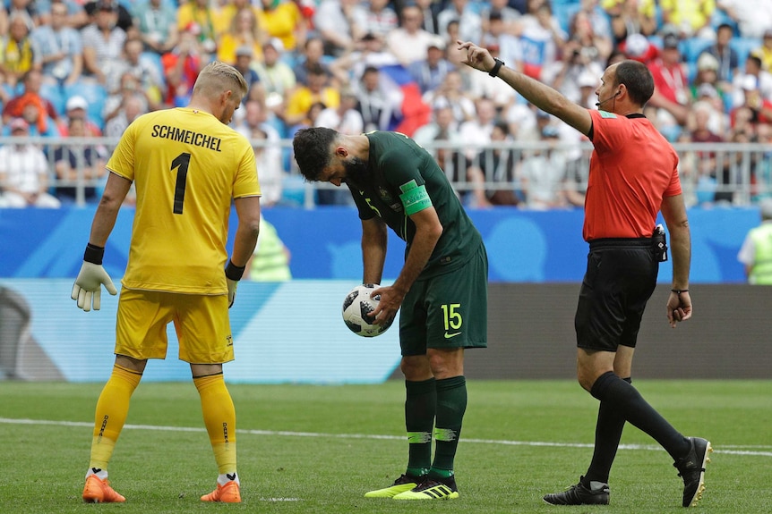 Kasper Schmeichel talks to Mile Jedinak as he prepares for a penalty