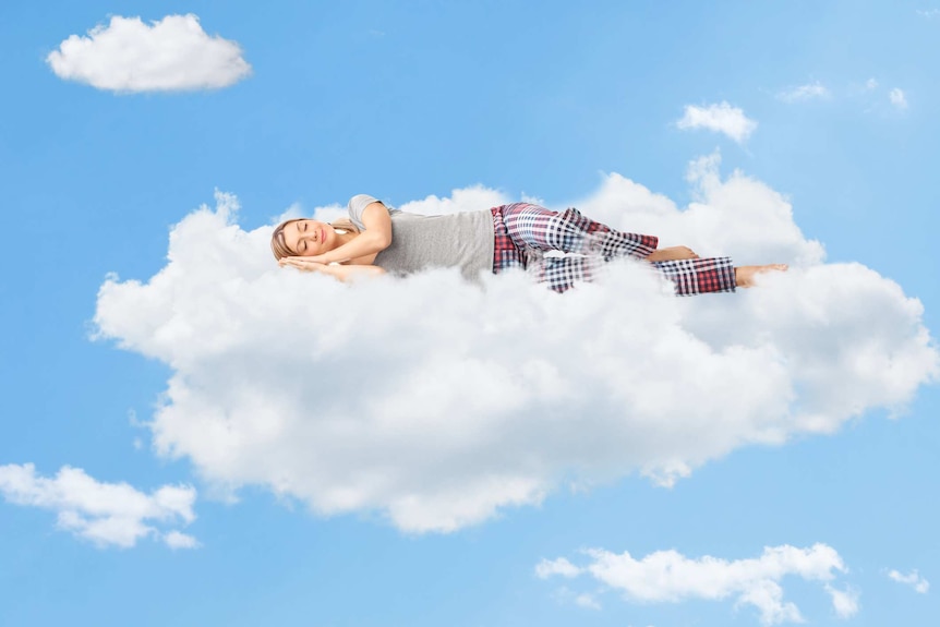 woman in pyjama pants and t-shirt sleeping on floating cloud