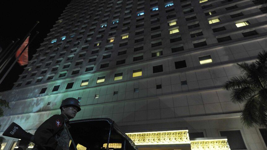 A Myanmar soldier stands guard outside the Traders Hotel in Yangon on October 14, 2013 after a suspected bomb blast shook the luxury hotel, leaving one US guest slightly wounded, police said.